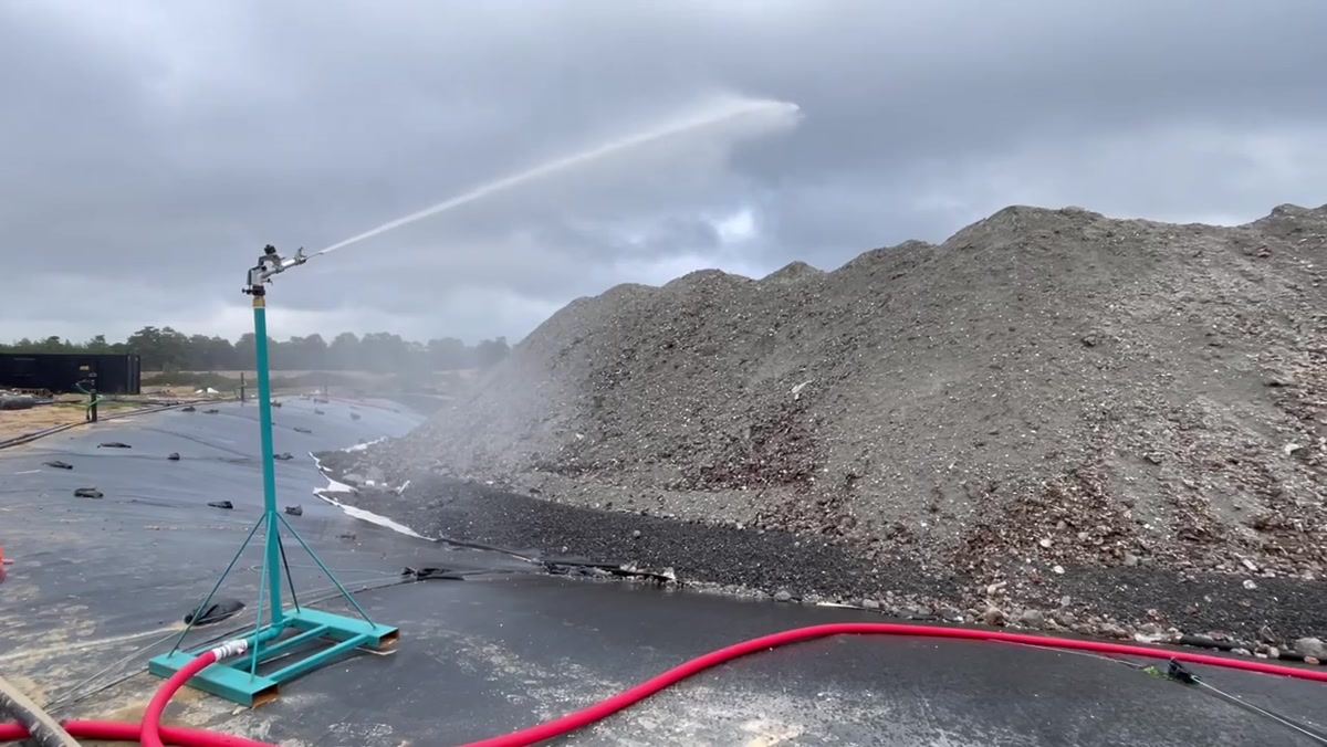 Rain gun assembly controlling dust at an aggregates processing site